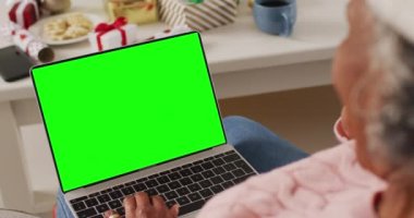 Kıdemli Afro-Amerikan kadın bilgisayar kullanarak fotokopi çektiriyor. İletişim teknolojisi ve noel, dijital kompozit video.