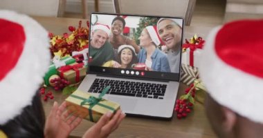 Çeşitli çiftler Noel 'de çeşitli insanlarla görüntülü görüşme yapıyorlar. İletişim teknolojisi ve noel, dijital kompozit video.