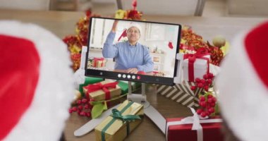 Noel Baba şapkalı çeşitli çiftler, melez bir adamla tablet görüntülü konuşma yapıyorlar. Noel, kutlama, dijital kompozit video.