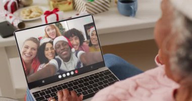 Noel 'de Noel Baba şapkalı Afro-Amerikan bir kadının ailesiyle yaptığı görüntülü konuşma. Noel, şenlik, gelenek ve kutlama konsepti dijital olarak oluşturuldu.