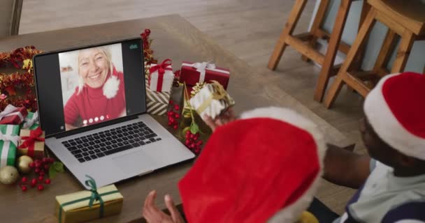 Zróżnicowana Para Kapeluszach Mikołaja Rozmawiająca Przez Laptopa Białą Kobietą Święta — Wideo stockowe