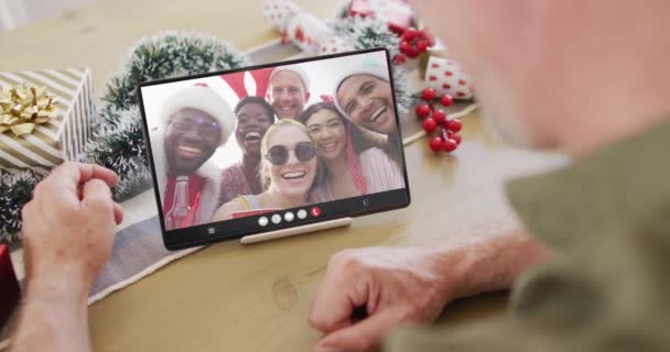 拥有圣诞装饰品的白人男子与不同的朋友进行了平板视频通话 圣诞节 庆祝活动 数码合成录像 — 图库视频影像