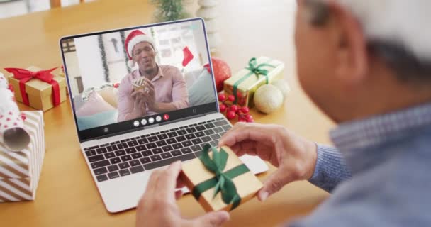 Birasowy Facet Kapeluszu Mikołaja Rozmawiający Przez Laptopa Afrykańskim Amerykaninem Święta — Wideo stockowe