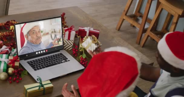 シニア出産の男とクリスマスビデオ通話を持っている多様なカップル 通信技術とクリスマス デジタル複合ビデオ — ストック動画