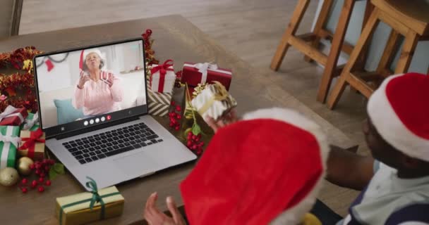 Diversa Pareja Con Sombreros Santa Tener Videollamada Portátil Con Mujer — Vídeos de Stock