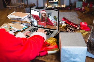 Kafkasyalı kıdemli bir adam Kafkasyalı bir kadınla Noel 'de görüntülü görüşme yapıyor. İletişim teknolojisi ve noel, dijital kompozit görüntü.