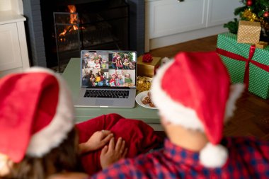 Kafkasyalı çift çeşitli insanlarla yılbaşı videosu çekiyor. İletişim teknolojisi ve noel, dijital kompozit görüntü.