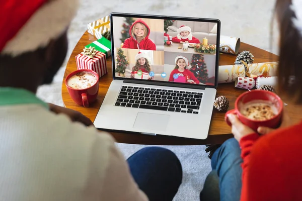 多様な子供たちとクリスマスビデオ通話を持つ多様なカップル 通信技術とクリスマス デジタル複合画像 — ストック写真