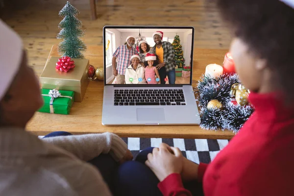 African american couple having christmas video call with african american family. Communication technology and christmas, digital composite image.