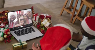 Noel Baba şapkalı çeşitli çiftler çeşitli arkadaşlarıyla dizüstü bilgisayar görüşmesi yapıyorlar. Noel, kutlama, dijital kompozit video.