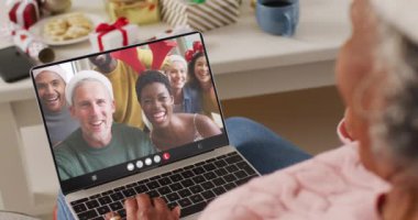 Kıdemli Afro-Amerikan kadın çeşitli insanlarla yılbaşı videosu çekiyor. İletişim teknolojisi ve noel, dijital kompozit video.