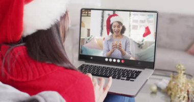 Noel Baba şapkalı beyaz bir kadının Noel 'de kadınla yaptığı görüntülü konuşma. Noel, şenlik, gelenek ve kutlama konsepti dijital olarak oluşturuldu.