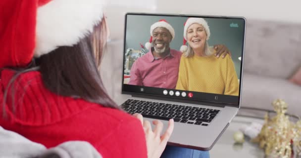 Blanke Vrouw Met Kerstmuts Met Laptop Videogesprek Met Diverse Echtparen — Stockvideo