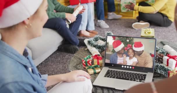 与非洲裔美国家庭有笔记本电脑视频通话的戴着桑塔帽的不同朋友 圣诞节 庆祝活动 数码合成录像 — 图库视频影像