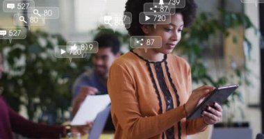 Ofiste tablet kullanan mutlu melez kadın hakkında sosyal medya bildirimleri. Küresel iletişim ağı, dijital arayüz, iş ve sosyal medya kavramı dijital olarak oluşturulmuş video.