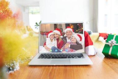 Kafkasyalı mutlu bir ailenin Noel 'de dizüstü bilgisayarında video görüşmesi var. Noel, kutlama ve dijital kompozit görüntü.