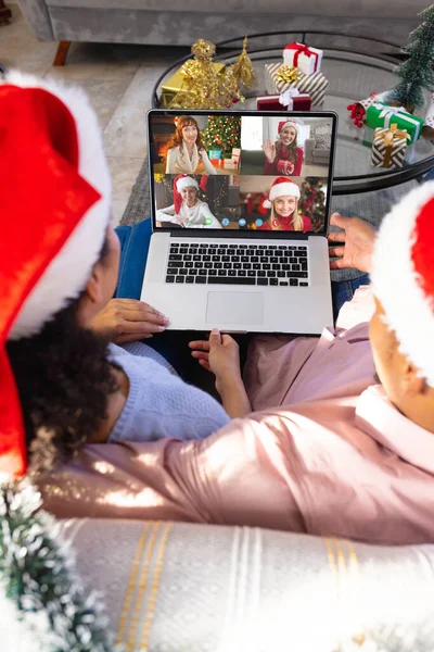 アフリカ系アメリカ人のカップルは 多様な人々とクリスマスビデオ通話をしています 通信技術とクリスマス デジタル複合画像 — ストック写真