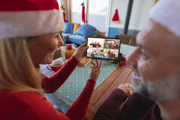 白种人夫妇戴着圣诞礼帽 与快乐的朋友们一起进行圣诞视频通话 圣诞节 庆祝活动和数码合成图像 — 图库照片