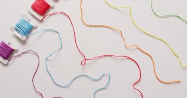 Beyaz arka planda altı tane rengarenk işlemeli ipliğin açılmamış videosu. Dikiş, dikiş, yaratıcılık, el işleri ve hobiler konsepti.