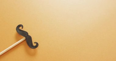 Sarı arkaplandaki sahte bıyıklı fotokopi alanı videosu. Babalar günü, kostüm, parti malzemeleri, eğlence ve kutlama konsepti..