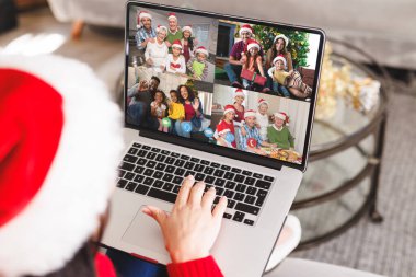 Noel Baba şapkalı beyaz bir kadın mutlu arkadaşlarıyla görüntülü görüşme yapıyor. Noel, kutlama ve dijital kompozit görüntü.