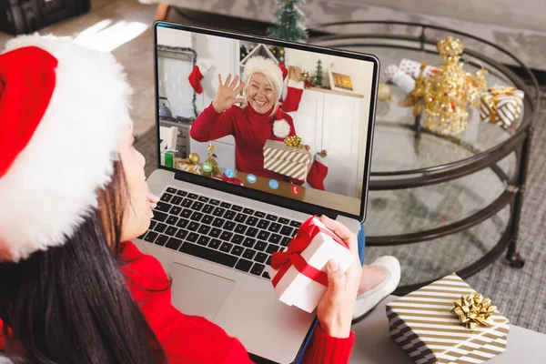 幸せな白人女性とビデオ通話を持つサンタの帽子を持つ白人女性 クリスマス お祝いとデジタル複合画像 — ストック写真