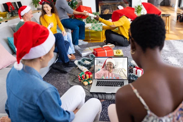 幸せなアフリカ系アメリカ人女性とビデオ通話を持つクリスマスの装飾を持つ多様な友人 クリスマス お祝いとデジタル複合画像 — ストック写真