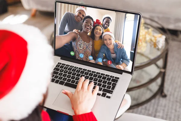 サンタ帽子を被った白人女性は幸せな多様な友人とビデオ通話をしています クリスマス お祝いとデジタル複合画像 — ストック写真