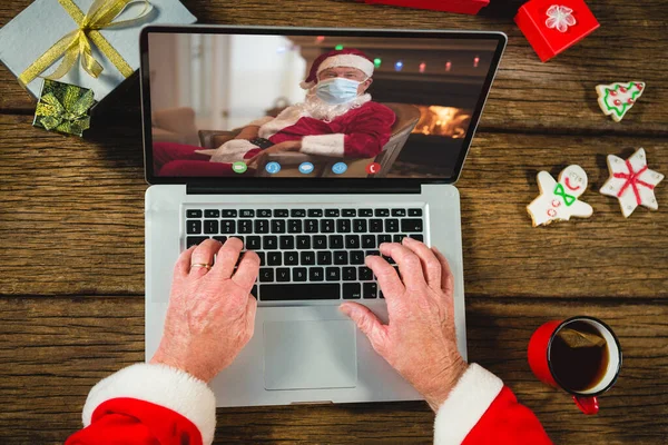 stock image Senior caucasian man having christmas video call with senior caucasian man. Communication technology and christmas, digital composite image.