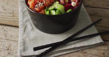 Pirinç, somon ve sebze kompozisyonu ve ahşap zemin üzerinde yemek çubukları. Yiyecek, içecek ve renk konsepti.