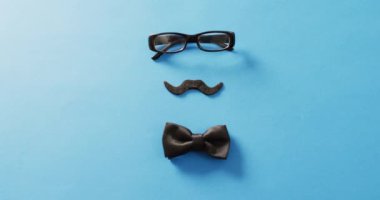 Takma bıyıklı, siyah gözlüklü ve siyah papyonlu bir video. Babalar günü, kostüm, parti malzemeleri, eğlence ve kutlama konsepti..