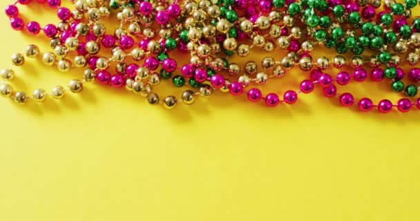 Video Růžové Zlaté Zelené Mardi Gras Karnevalové Korálky Žlutém Pozadí — Stock video