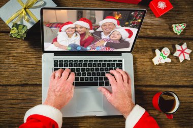 Noel hediyeli Noel Baba mutlu beyaz bir aileyle görüntülü görüşme yapıyor. Noel, kutlama ve dijital kompozit görüntü.