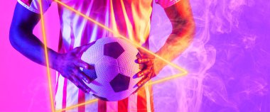 Aydınlatılmış üçgen ve duman ile topu tutan melez erkek oyuncunun orta bölümü, kopyalama alanı. Kompozit, spor, futbol, rekabet, neon, illüstrasyon, parlama, duman ve soyut kavram.