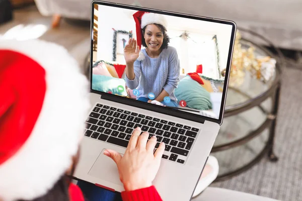白人女性はアフリカ系アメリカ人女性とクリスマスビデオ通話をしている 通信技術とクリスマス デジタル複合画像 — ストック写真