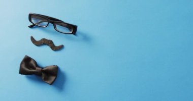 Takma bıyıklı, siyah gözlüklü ve siyah papyonlu bir video. Babalar günü, kostüm, parti malzemeleri, eğlence ve kutlama konsepti..