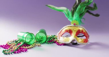 Yeşil tüylü, Mardi Gras boncuklu ve shot bardaklı karnaval maskesi, fotokopi alanı. Karnaval, kostüm, parti malzemeleri, eğlence ve kutlama konsepti..