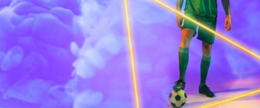 Beyaz tenli erkek oyuncunun dumanlı arka planda aydınlatma üçgeniyle topun üzerinde bacağı olan alt kısmı. Boşluğu kopyala, kompozit, mavi, spor, futbol, rekabet, neon, illüstrasyon, parlama ve soyut.