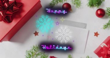 Bu videoda neon ışıklarla yazılmış mutlu bir tatil mesajı ve düşen kar taneleri yer alıyor. İleti siyah bir arkaplan üzerine kurulu ve videoda kırmızı noel süslemeleri ve zarfları da yer alıyor..