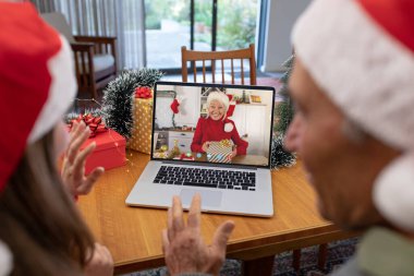 Kafkasyalı baba ve kızı, Kafkasyalı bir kadınla yılbaşı videosu çekiyor. İletişim teknolojisi ve noel, dijital kompozit görüntü.