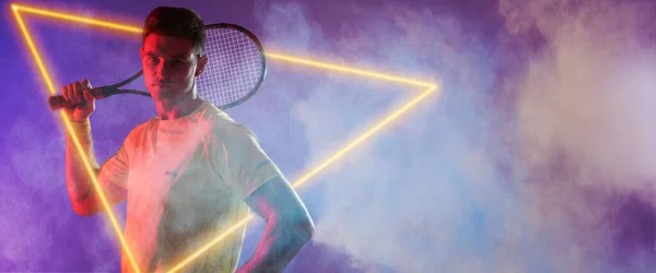 Kaukasische Männliche Tennisspieler Halten Schläger Durch Beleuchtetes Dreieck Auf Lila — Stockfoto