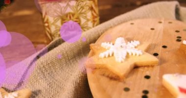 Kurabiyeler ve Noel hediyesi üzerine mor noktaların animasyonu. kış, noel ve gelenek konsepti dijital olarak oluşturulmuş video.