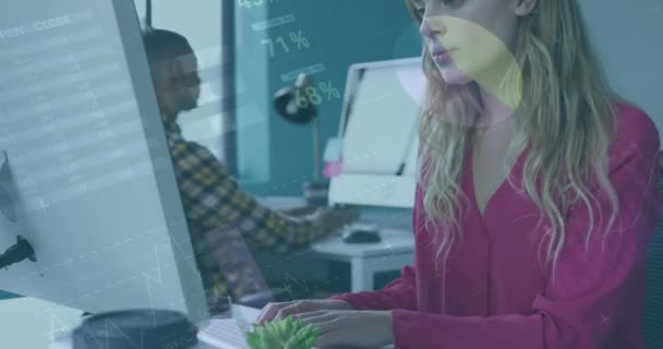 創造的なオフィスで働いている白人女性 彼女のコンピュータ画面を見て 彼女の混合人種の男性同僚は近くの彼の机で働いています — ストック動画
