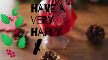 Şekerlerin üzerinde çok mutlu bir xmas metni ve ahşap arka planda süslemeler var. Noel, gelenek ve kutlama konsepti dijital olarak oluşturuldu.