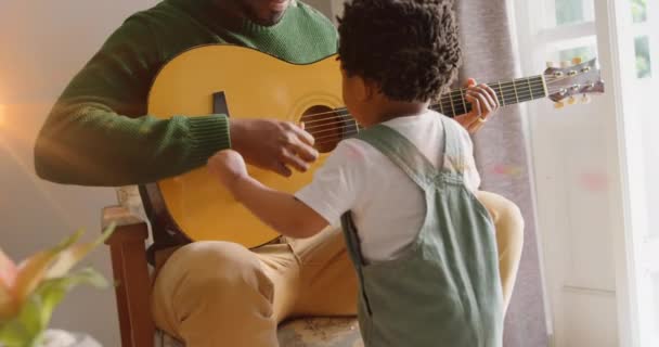 Анимация Вспышки Света Над Счастливыми Африканскими Отцом Сыном Играющими Гитаре — стоковое видео