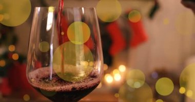 Odadaki bir kadeh şarabın üzerinde yılbaşı süslemeleriyle hareket eden noktaların animasyonu. Noel, kış, gelenek ve kutlama konsepti dijital olarak oluşturuldu.