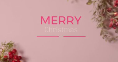 Mutlu noeller ve mutlu yeni yıl afişleri pembe yüzeydeki kırmızı kirazlar üzerinde. Noel şenliği ve kutlama konsepti