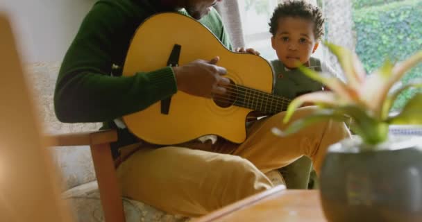 아프리카 미국인 아버지와 기타를 연주하는 가운데 반짝이는 애니메이션 그리고 시간을 — 비디오