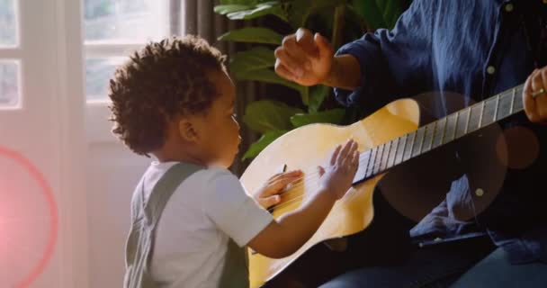 Animación Luz Parpadeando Sobre Madre Hijo Afroamericanos Tocando Guitarra Familia — Vídeos de Stock