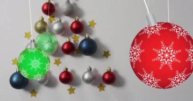 Renkli Noel süsleri asma animasyonu gri arka planda takılıyor. Noel şenliği ve kutlama konsepti